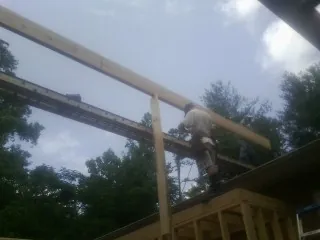 Carpenter setting a ridge beam over a new addition frame — Ice Dam Removal by Roofing Brothers in Allenwood