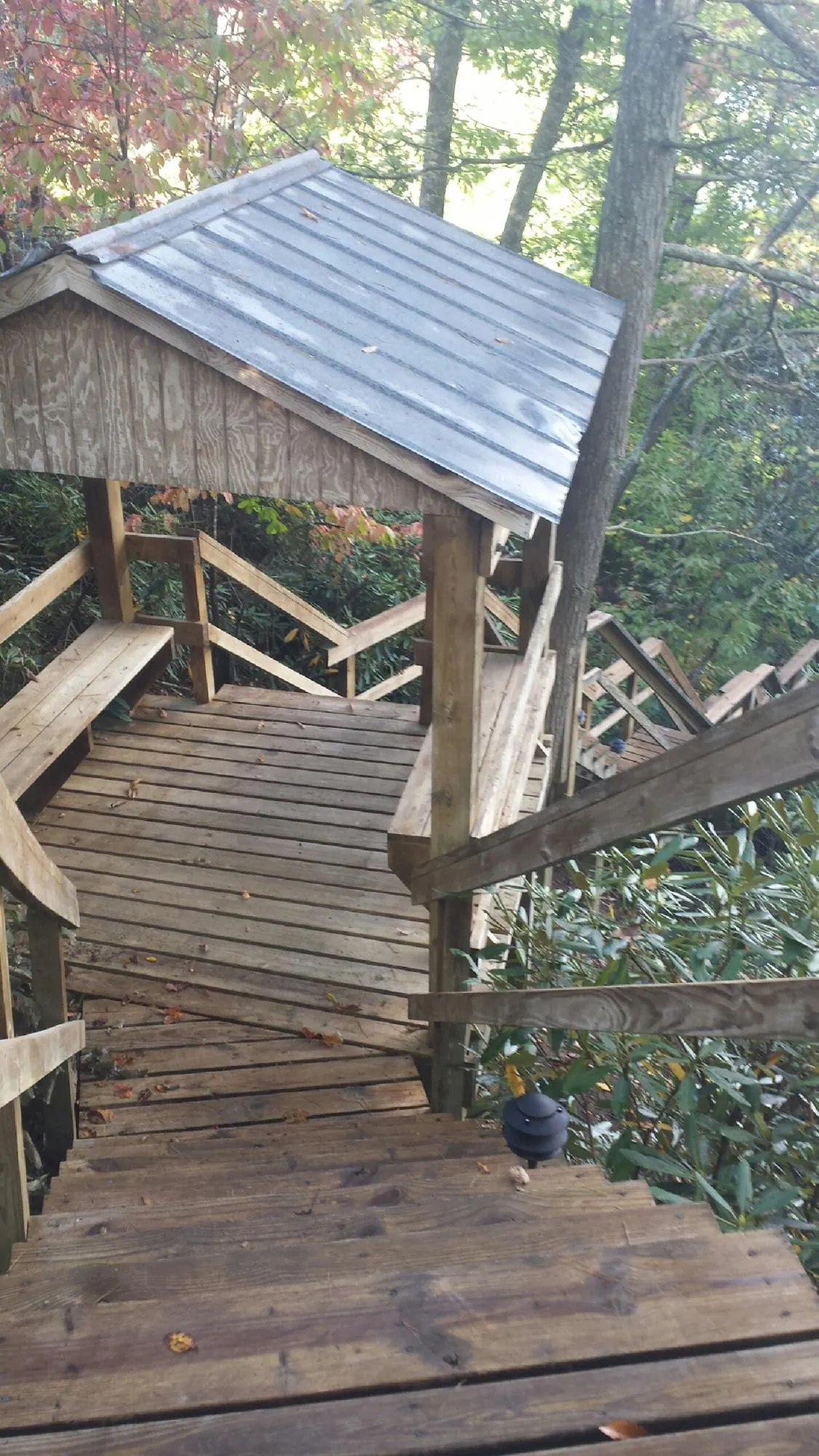 Metal roofed shelter over wooden steps on a wooded walkway — Skylight Repair & Installation work by our crew in Allenwood